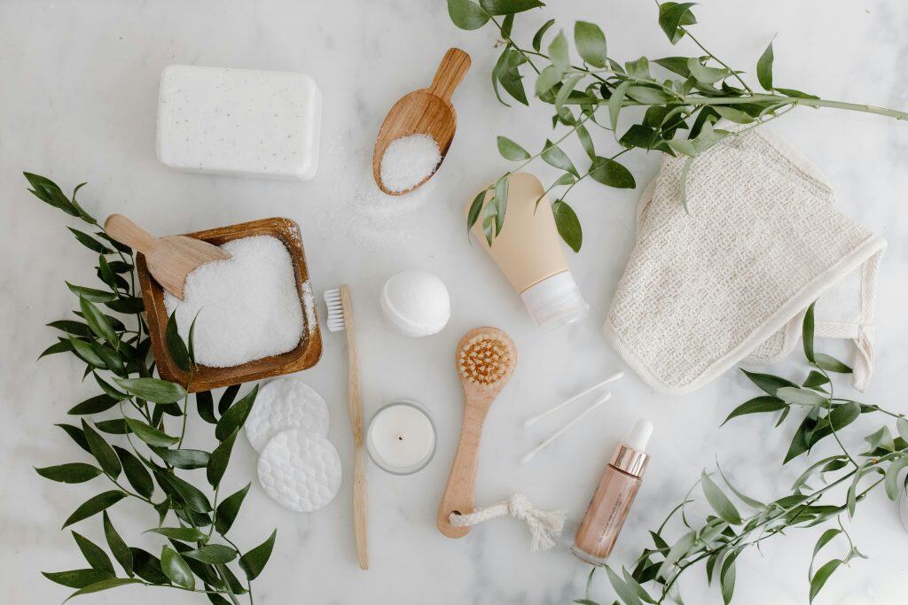 exfoliating skincare products and eco-friendly beauty accessories on marble surface with greenery, promoting natural and sustainable self-care at The Spotless Spot